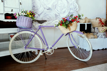 Fototapeta na wymiar Bicycle with two baskets of flowers. Home decor