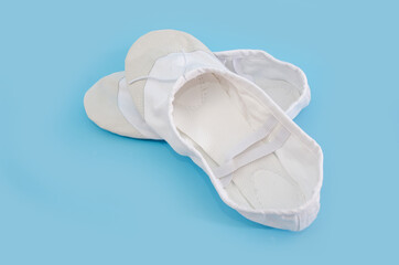 White ballet flats for dancing isolated on blue background. Shoes for trainers in the fitness room.