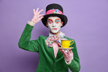 Time for having tea. Aristocratic gentleman with bright makeup has image of fictional character...