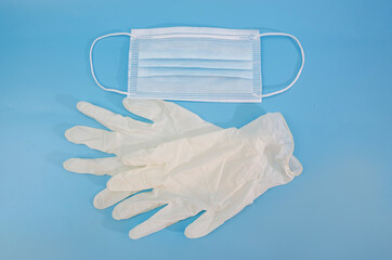 white latex gloves and mask isolated on blue background. Antivirus protection tool.