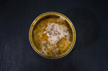 open can of salmon on black background