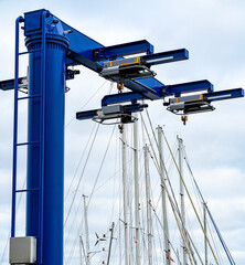 Blue heavy lift boat crane at the marina, ready to lift boats in and out of the water for...
