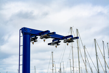 Blue heavy lift boat crane at the marina, ready to lift boats in and out of the water for...