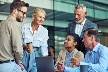 Having a meeting. Group of multiracial business people in classic wear working together on a new...