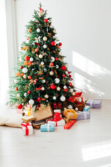Christmas tree by the window with gift decor for the new year interior of the holiday house