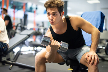 Bodybuilder using a dumbbell to work out in a gym