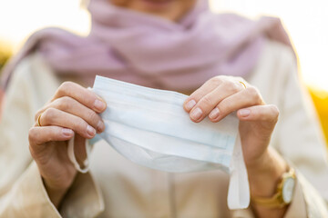 Close-Up Of Senior Woman’s Hands Holding Protective Face Mask
