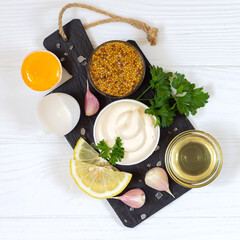Ingredients for making mayonnaise sauce on stone board top view