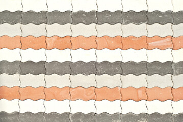 Cobblestone texture. The sidewalk tile is evenly folded. Multicolored cobblestones close up.