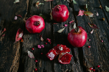 ripe pomegranates on a dark table. Autumn still life. Rustic style.