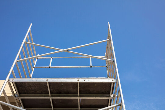 Renovation concept, scaffold tower. Below to upper front view, blue sky background.