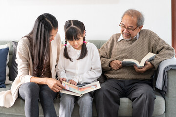 Daughter reading story with mom and grandfather