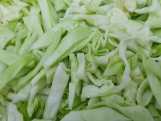 Sliced Cabbage background. Fresh cabbage from farm field. Close up macro view of green cabbages. Vegetarian food concept. slide white cabbage closeup ready to cooking. Popular Green vegetable. 