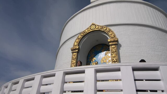 Pokhara, Nepal. Female praying in Pokhra's Peace stupa.