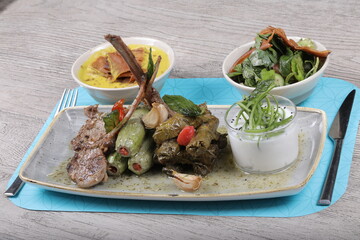 Dish Stuffed eggplant Beside tomato sauce and rice and minced meat with Lentil soup dish And Rocca Salad serve with fried bread