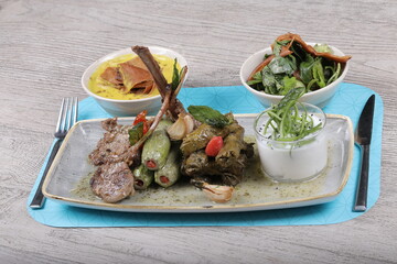 Dish Stuffed eggplant Beside tomato sauce and rice and minced meat with Lentil soup dish And Rocca Salad serve with fried bread