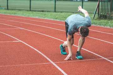 Young Caucasian man standing in start position for run