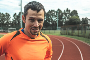 Close up portrait of a smiling Caucasian man at an athletic stadium