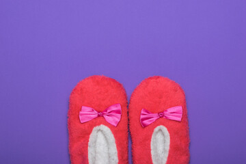 Pink and white house Slippers with a bow on a lilac background. Shoes for vacation.