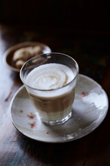 Glass of Latte Macchiato. Rustic wooden background. Close up.