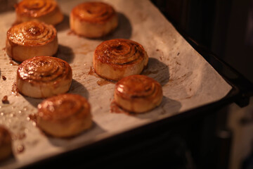rosy cinnamon rolls on a baking sheet in the oven, sweet rolls in the oven