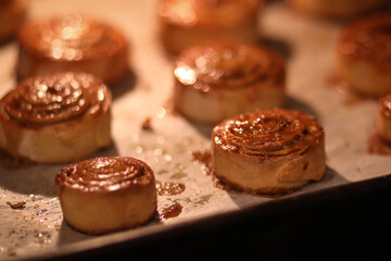 rosy cinnamon rolls on a baking sheet in the oven, sweet rolls in the oven