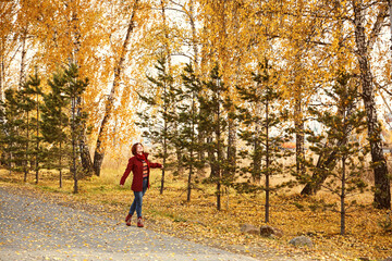 woman with yellow leaves in autumn park.