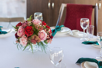 A beautiful floral arrangement of red flowers is on the table in the restaurant