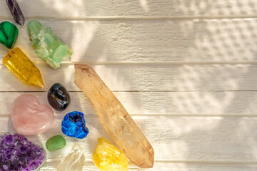 Different minerals and crystals on the white wooden background