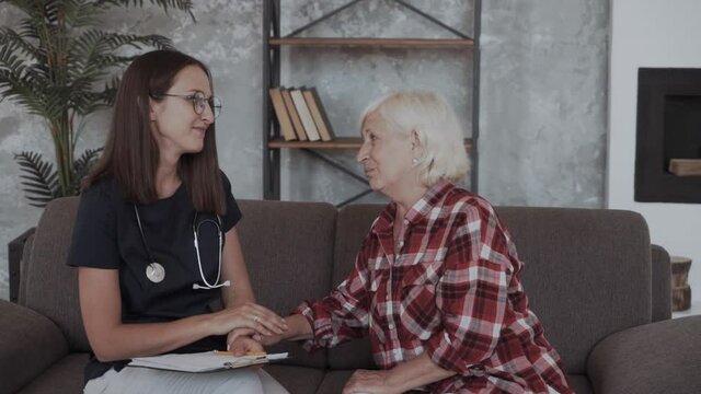 Senior Woman In Discussion With Health Visitor At Home
