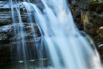 waterfall jets in a mountain stream between rocks, the water is blurred in motion