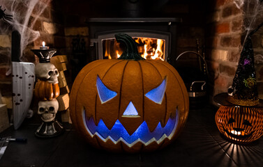 Haunted Halloween pumkin infront of fireplace with props eitherside