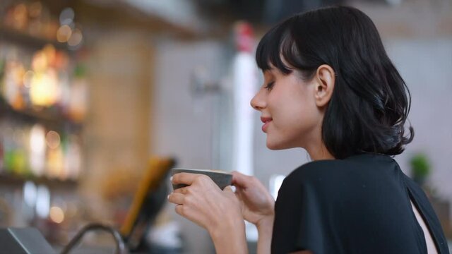 Closeup and slow motion caucasian woman smelling coffee and smiling.