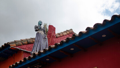 Fototapeta na wymiar Estatua artistica ubicada y escondida sobre techo de la ciudad de Bogota en el centro historico
