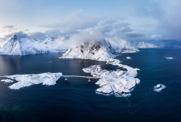 Winter landscape from air. Aerial view on the Hamnoy village, Lofoten Islands, Norway. Landscape during blue hour. Mountains and water. Travel - image