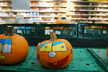 two orange pumpkins painted on Halloween in a supermarket front view
