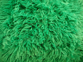 the lint of the green faux fur is close . green fabric texture