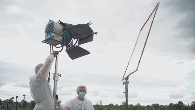 A team of filmmakers at work. Compliance with antiviral safety measures during quarantine. Personal protective equipment against coronavirus.