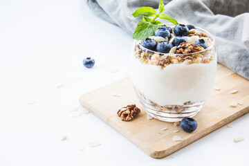 Healthy blueberry and walnut parfait in a glass on a white background