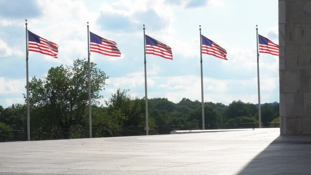 Washington Monument Plaza with American flags waving, representing US Federal Government and D.C. politics