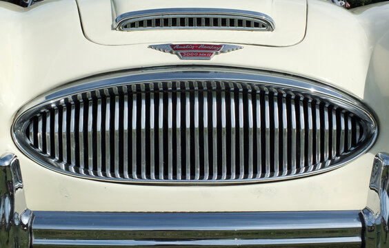 Hebden Bridge, West Yorkshire, England - August 5 2018:  chrome grill bumper and badge of a vintage white austin healey 300 classic sports car at hebden bridge vintage weekend public vehicle show