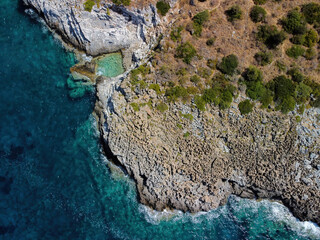 Aerial panoramic view of rocky beach and small pond near Trachila, Messinia, Greece