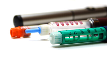 three insulin pens, injector pens, injector pens and a cartridge on a white background close up,...