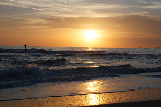 surfista sulle onde al tramonto © tommypiconefotografo