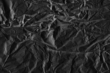 Black vintage and old looking crumpled paper background. Retro cardboard texture. Grunge paper for drawing. Ancient book page. Present wrapping.
