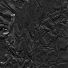 Black vintage and old looking crumpled paper background. Retro cardboard texture. Grunge paper for drawing. Ancient book page. Present wrapping.