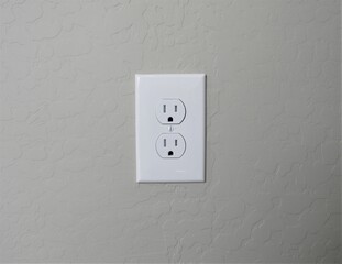 A white American electrical outlet on a stucco wall in southwest America