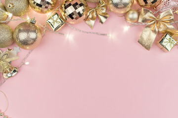 Merry Christmas background concept, new year card gold decoration frame on pink pastel table, flatly, copy space.