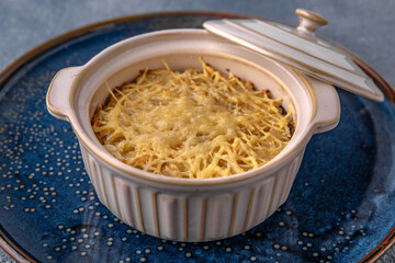 Casserole, risotto, or lasagne with cheese. Natural delicious food. Greek cuisine menu. Still life in a marine style on a blue background.