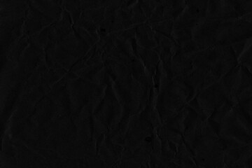 Black vintage and old looking crumpled paper background. Retro cardboard texture. Grunge paper for drawing. Ancient book page. Present wrapping.